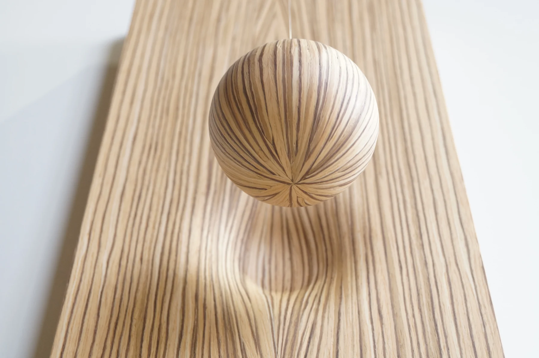 Birth of a sphere: detail of the veneered sphere and the panel from which it emerges.