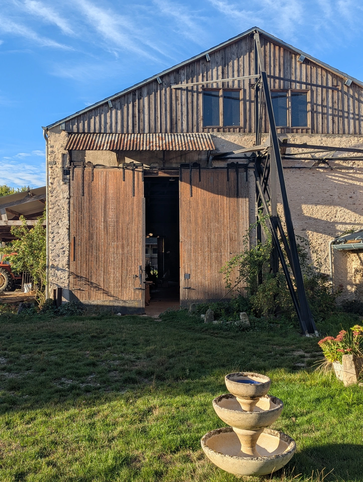 The barn at La Cheraille, with its wooden doors opening onto the workshop and garden.